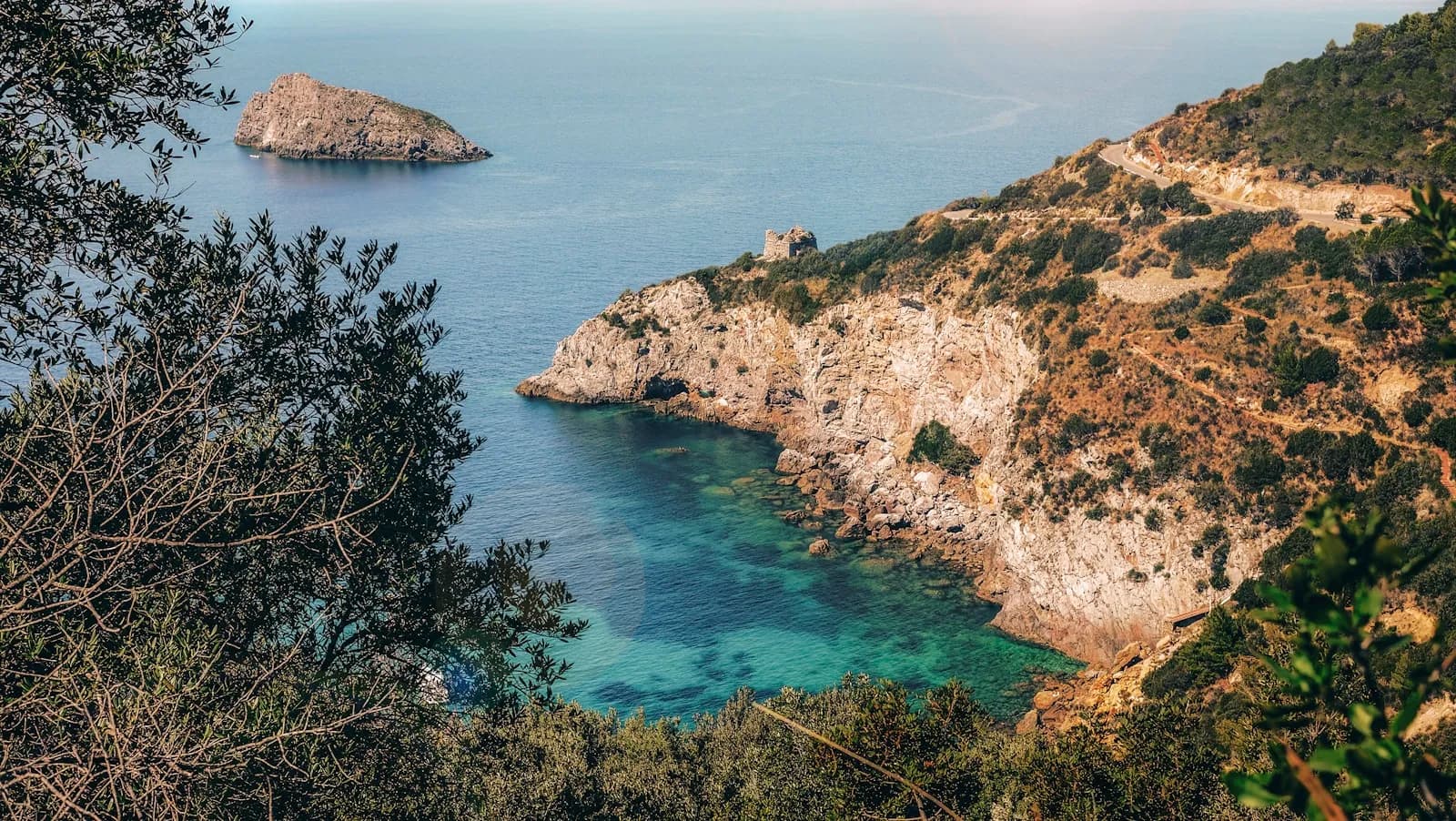 Cala rocciosa con acqua turchese trasparente e fondale visibile, ideale per lo snorkeling