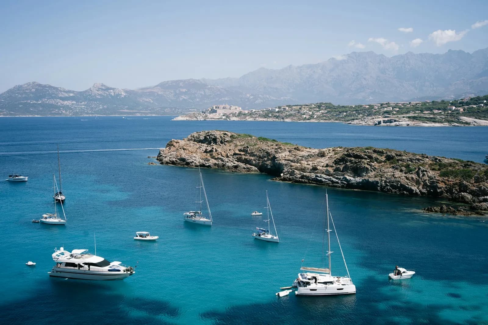 Barche a vela e yacht alla fonda in una baia del Mediterraneo in piena estate