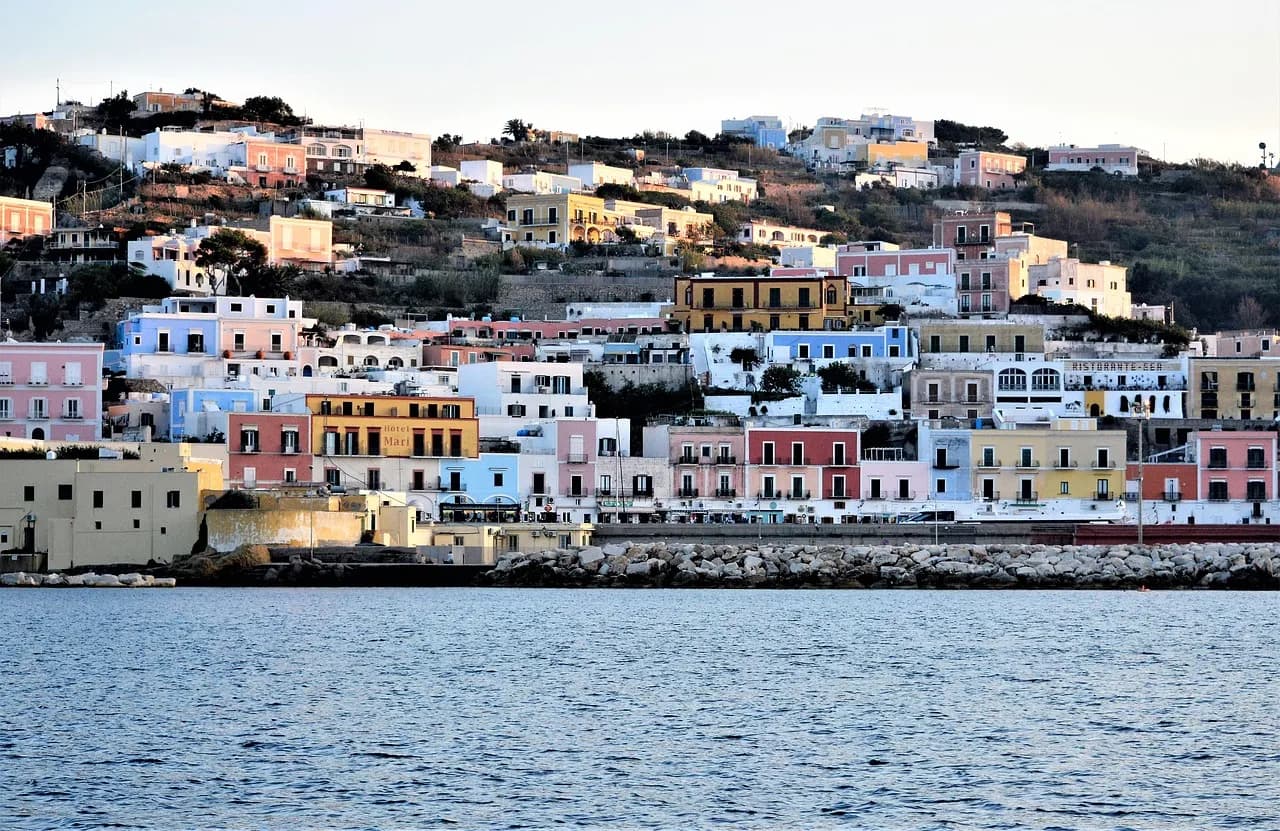 Il borgo di Ponza visto dal mare, con le case color pastello che salgono sulla collina sopra il lungomare