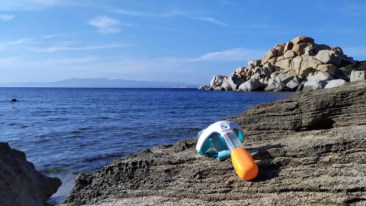 Maschera da snorkeling appoggiata su scogliera rocciosa, mare aperto sullo sfondo