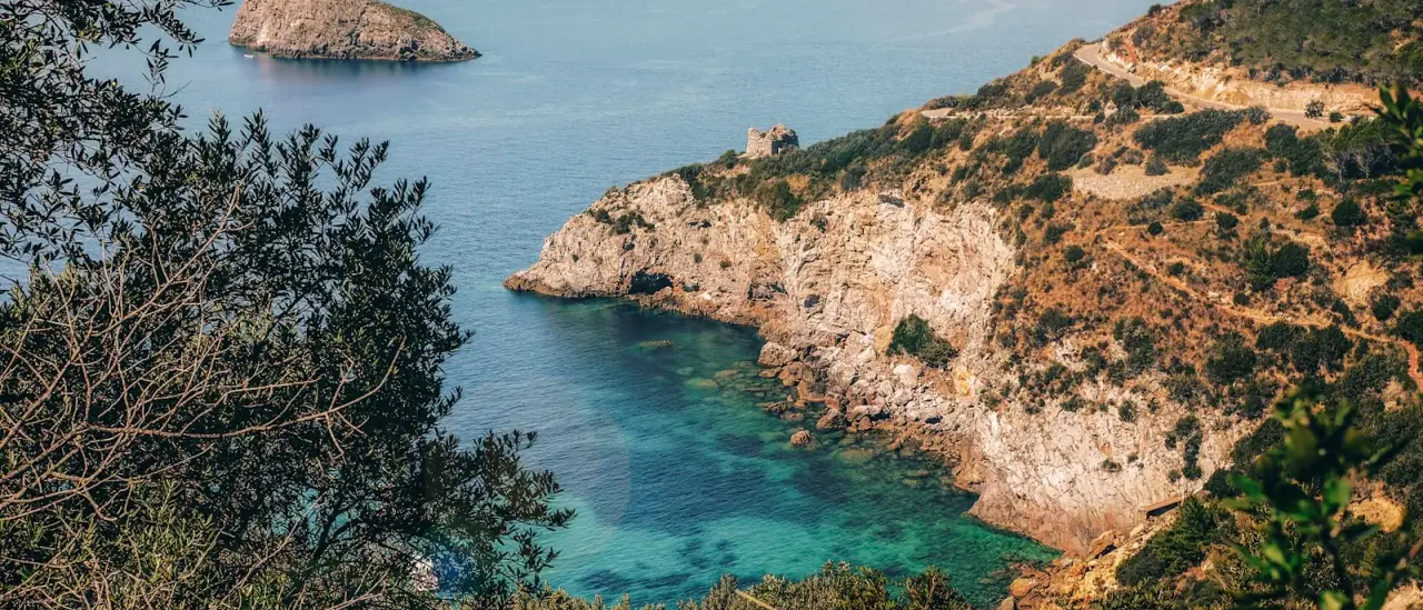 Cala rocciosa con acqua turchese trasparente e fondale visibile, ideale per lo snorkeling