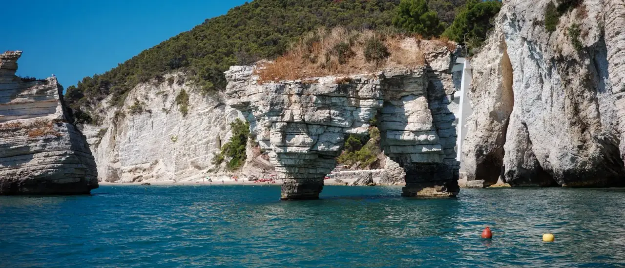 Le falesie calcaree e i faraglioni della Baia delle Zagare sul Gargano visti dal mare