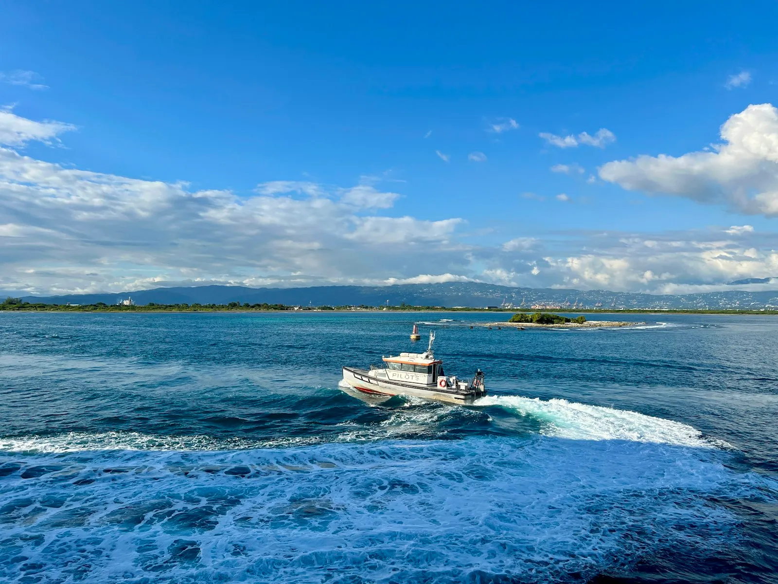 Piccola barca cabinata bianca naviga su un mare blu