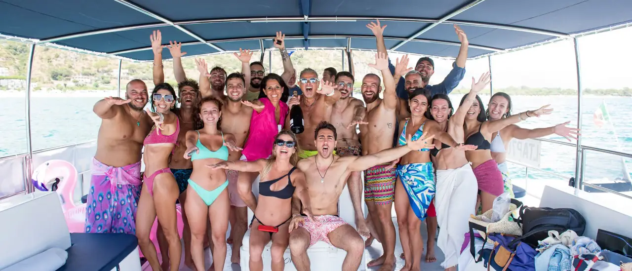 Gruppo a bordo del catamarano Euphoria durante un'escursione a San Felice Circeo, con mare e falesie sullo sfondo