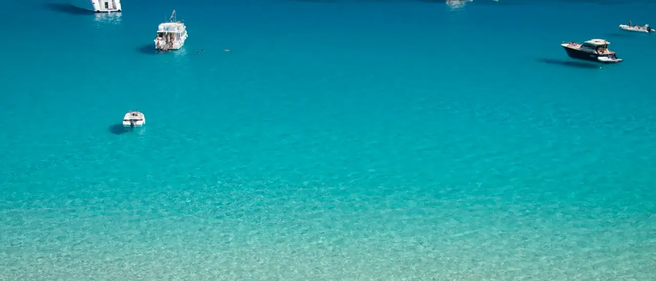 Favignana vista dal mare con le sue acque turchesi e la costa rocciosa delle Isole Egadi