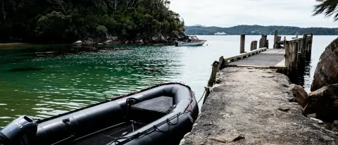 Gommone semirigido ormeggiato a un pontile su acqua calma