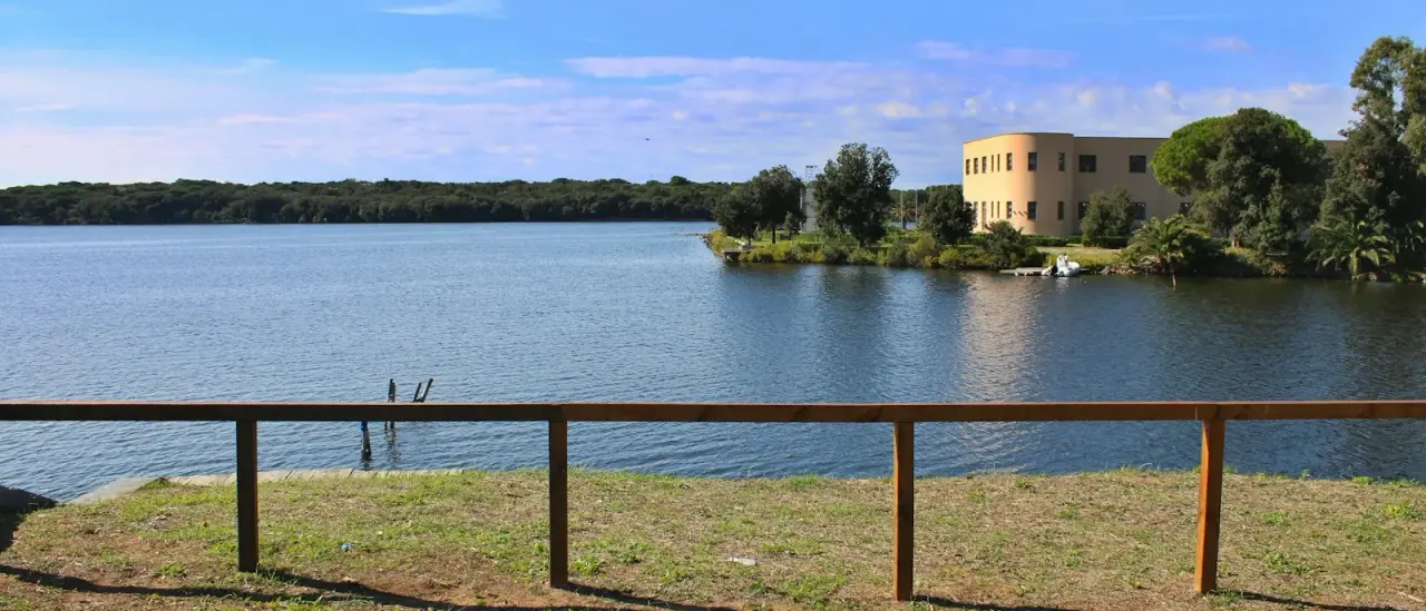 Il Lago di Paola a Sabaudia, acque calme con un edificio storico sulla riva opposta