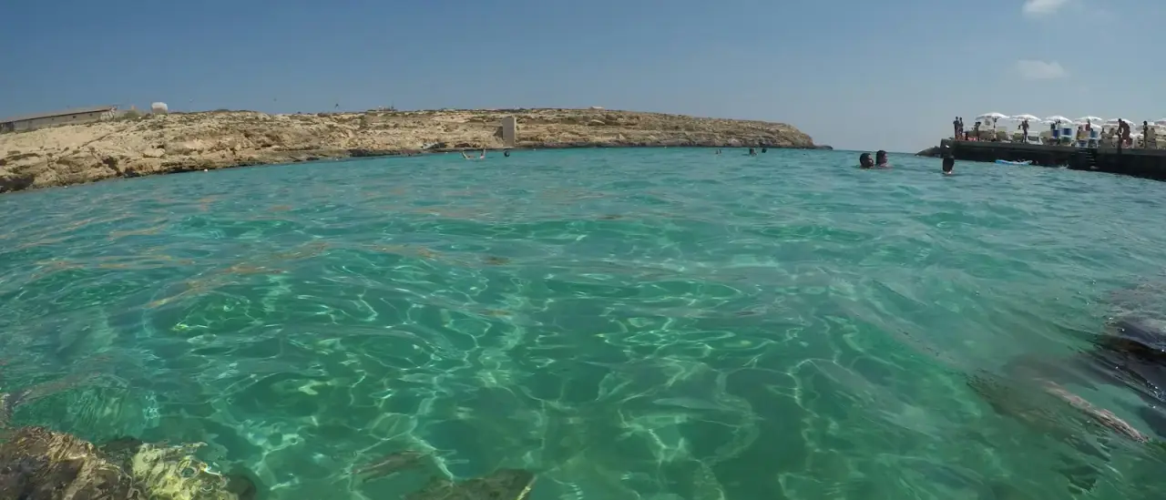 Le acque turchesi e basse di Lampedusa tra le rocce