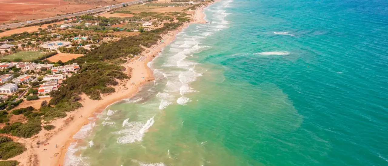Spiaggia sabbiosa e acqua turchese bassa del litorale pugliese