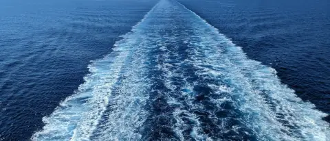 Barca a motore in navigazione d'altura su mare aperto lontano dalla costa