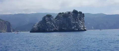 Lo scoglio roccioso di Capo Palinuro nel mare blu del Cilento, con piccole barche al largo