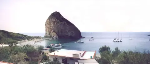 Cala del Porto a Palmarola, con il grande scoglio, il ristorante O'Francese e barche ormeggiate nella baia
