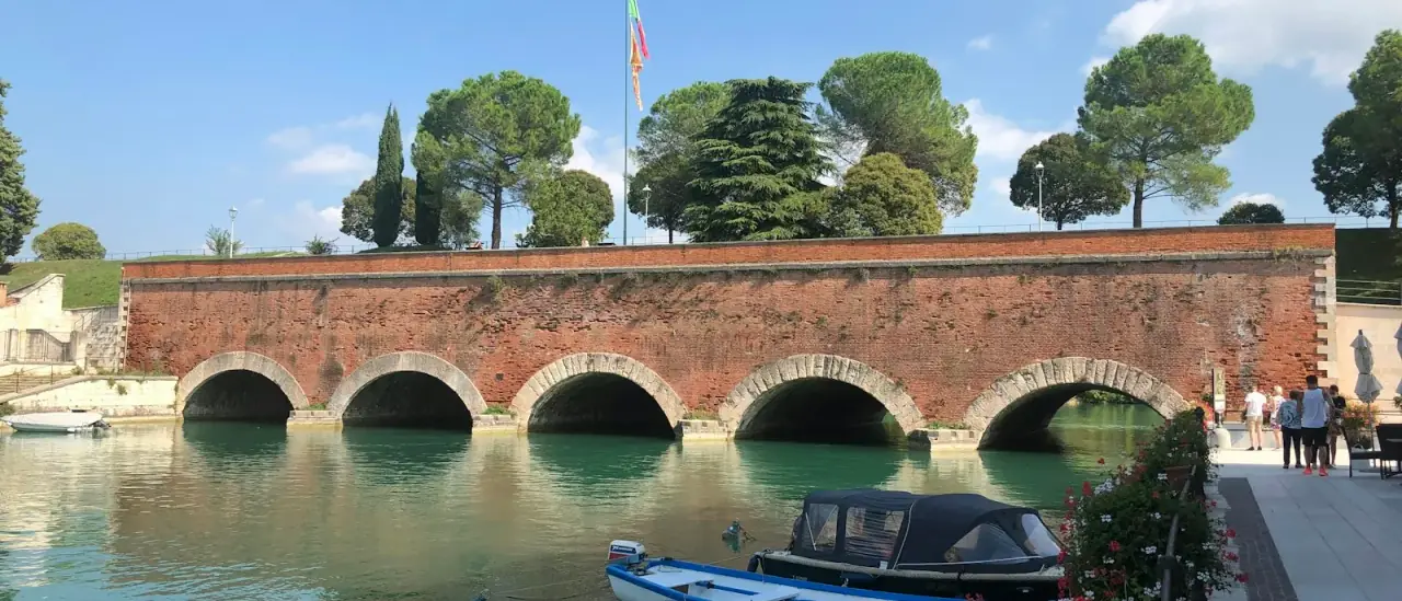 Il ponte veneziano di Peschiera del Garda con una barca ormeggiata sotto gli archi in mattoni