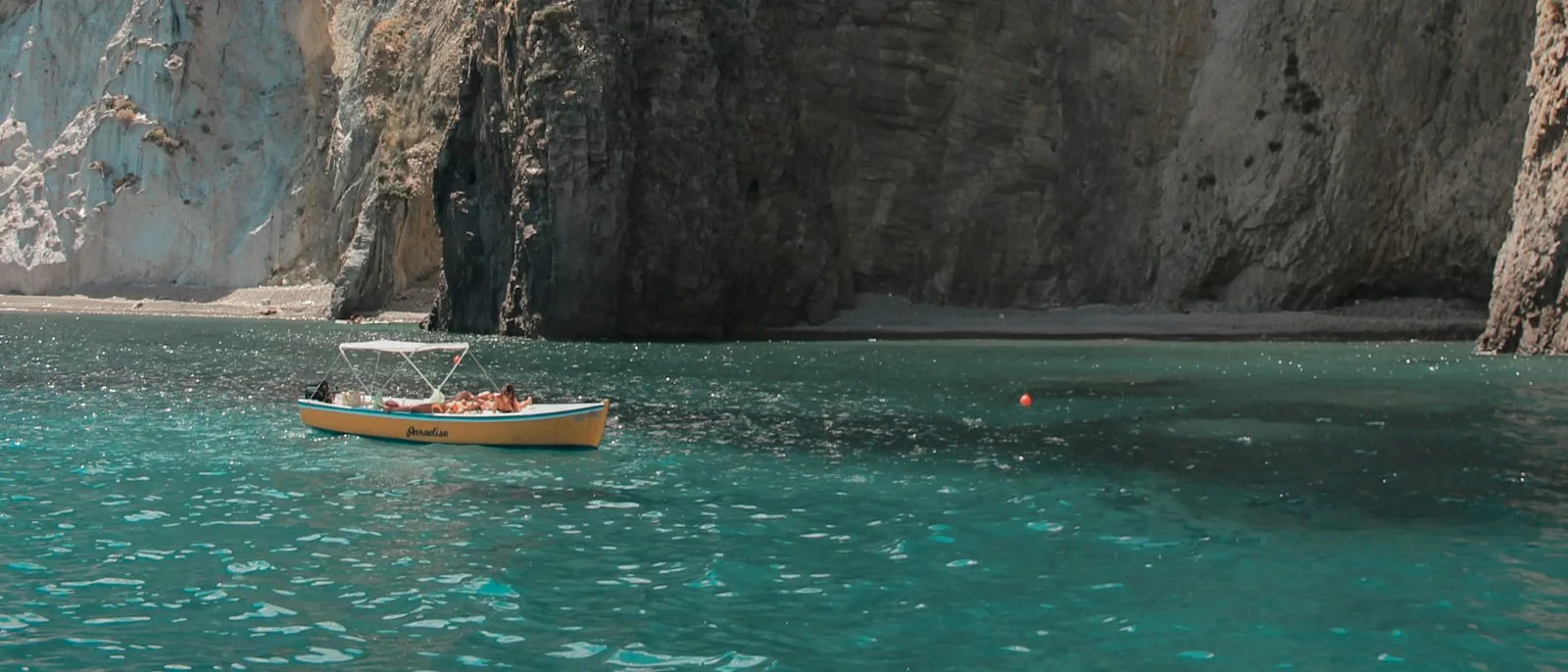 Una barca sul mare lungo la costa rocciosa dell'isola di Ponza
