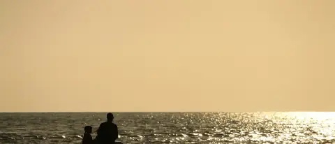 Coppia a bordo di una piccola barca al tramonto sul mare