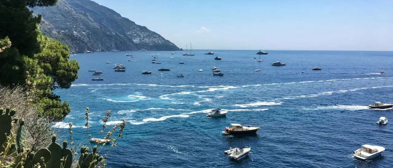 Numerose barche ancorate nella baia turchese davanti a Positano, Costiera Amalfitana