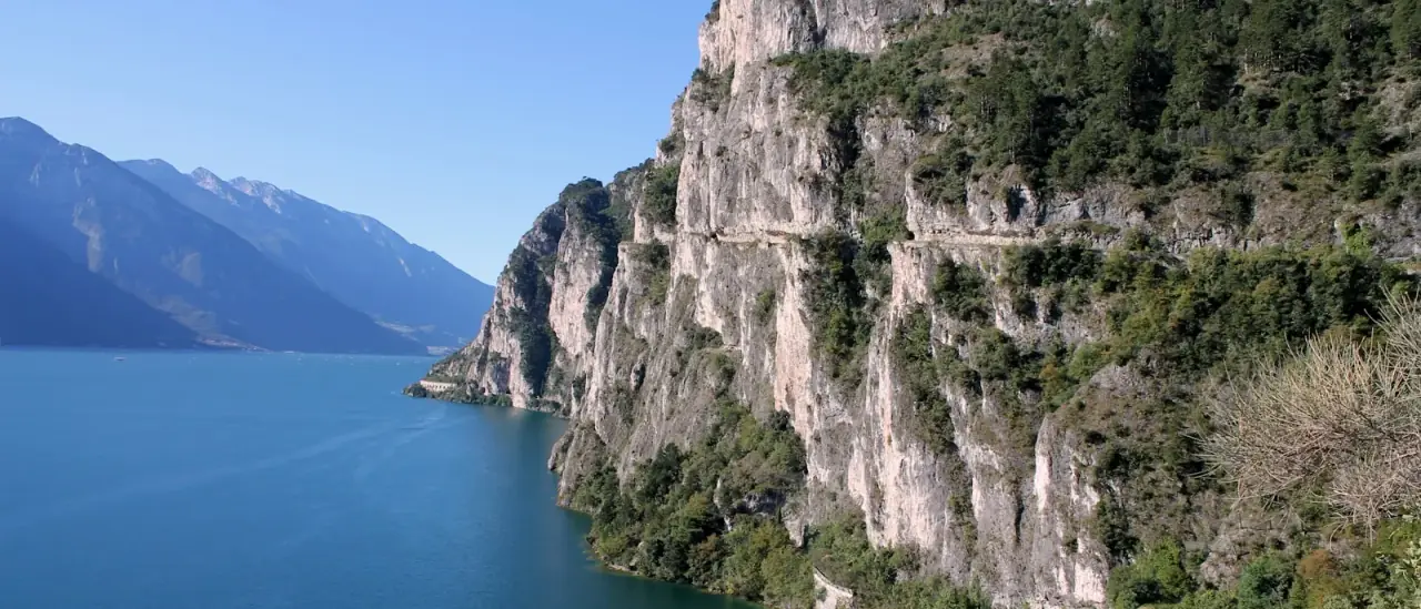Le pareti a picco dell'alto Garda vicino a Riva del Garda, con la strada scavata nella roccia lungo il lago