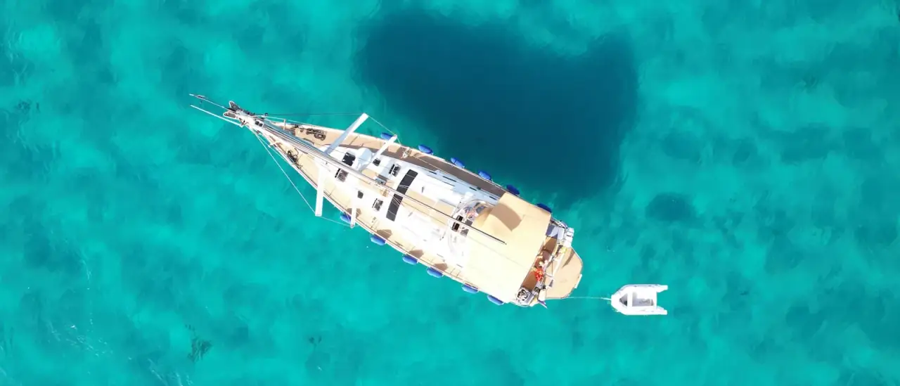 Veduta aerea di uno yacht ancorato in acque turchesi della Sardegna