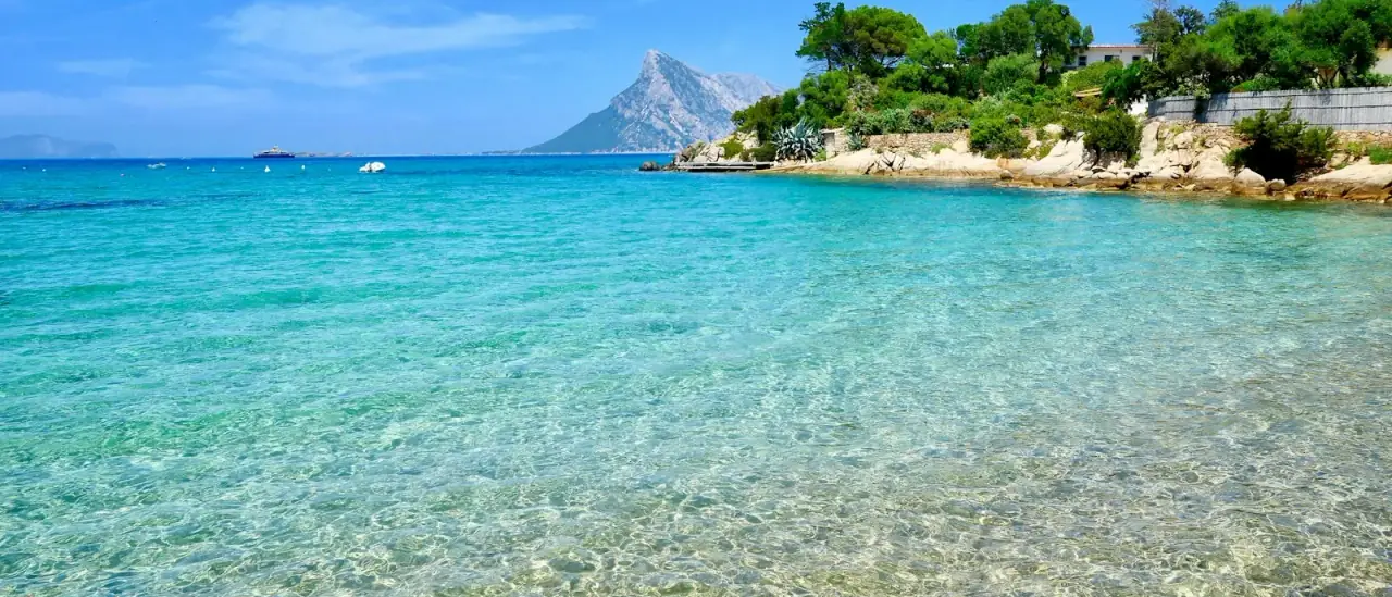 L'isola di Tavolara vista dal mare turchese, al largo della costa di San Teodoro