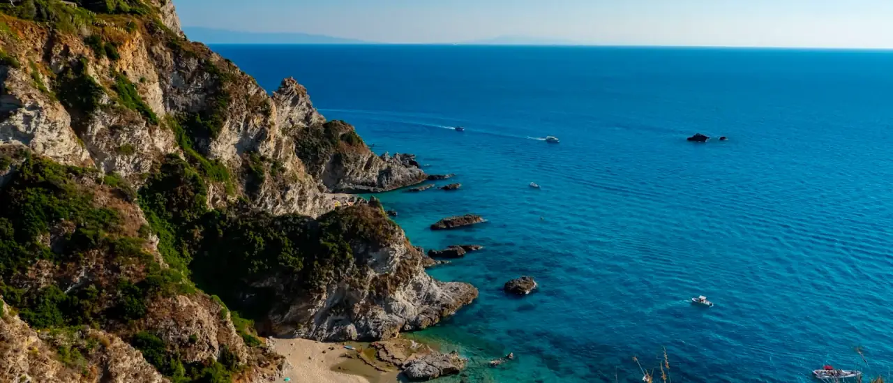 Barche all'ancora in una cala turchese della Costa degli Dei, in Calabria