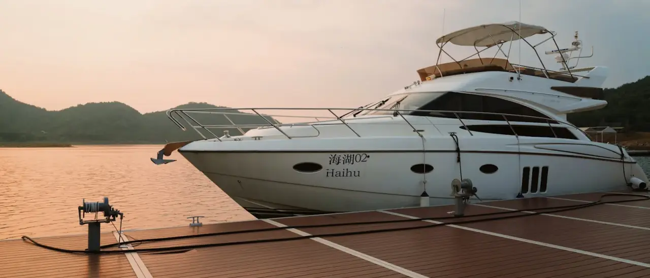 Yacht a motore bianco ormeggiato a una banchina in legno in una giornata serena